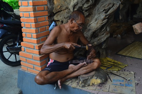 Man carving wood mass village